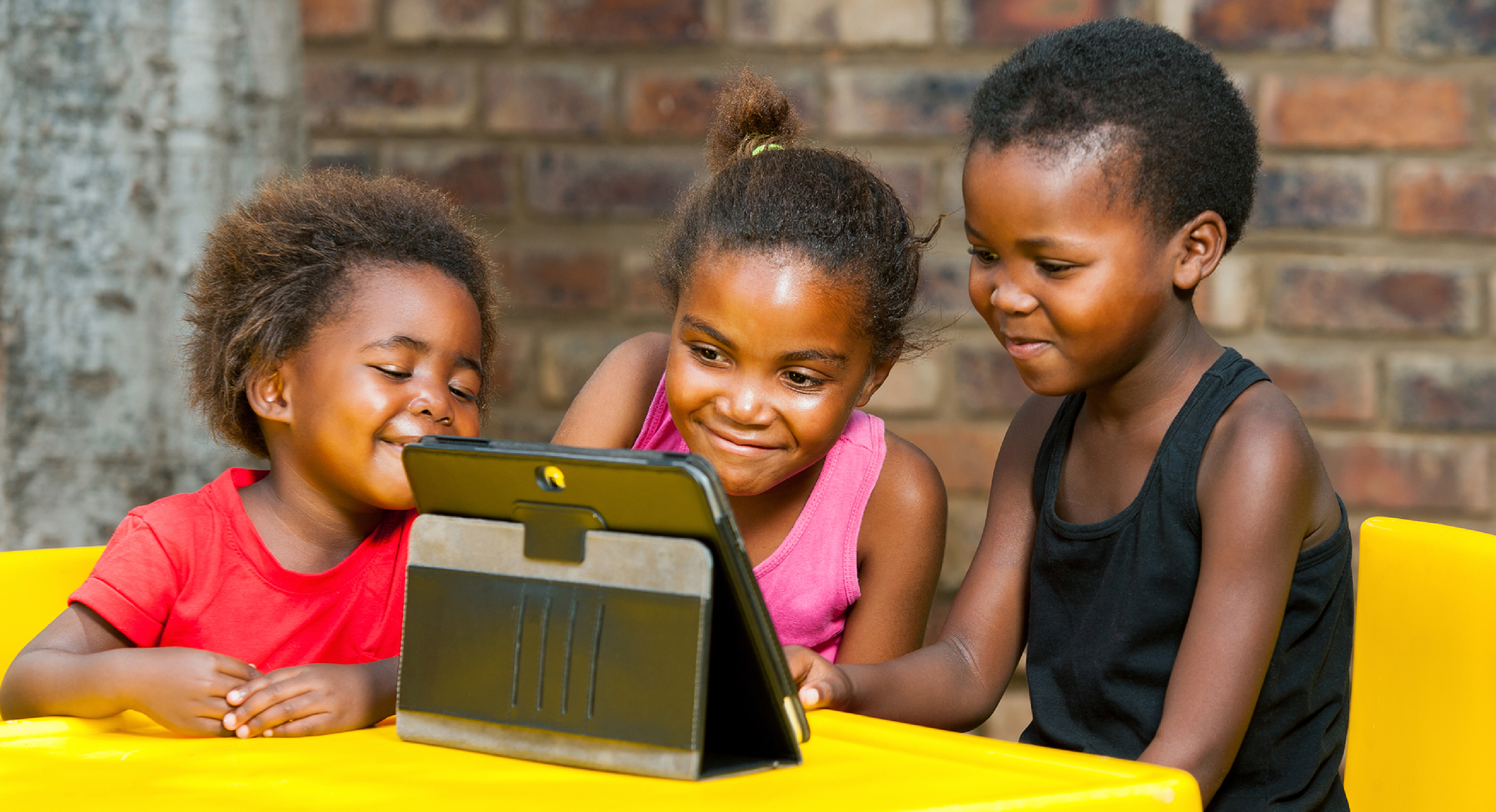 Three African Kids Playing Together On Tablet.